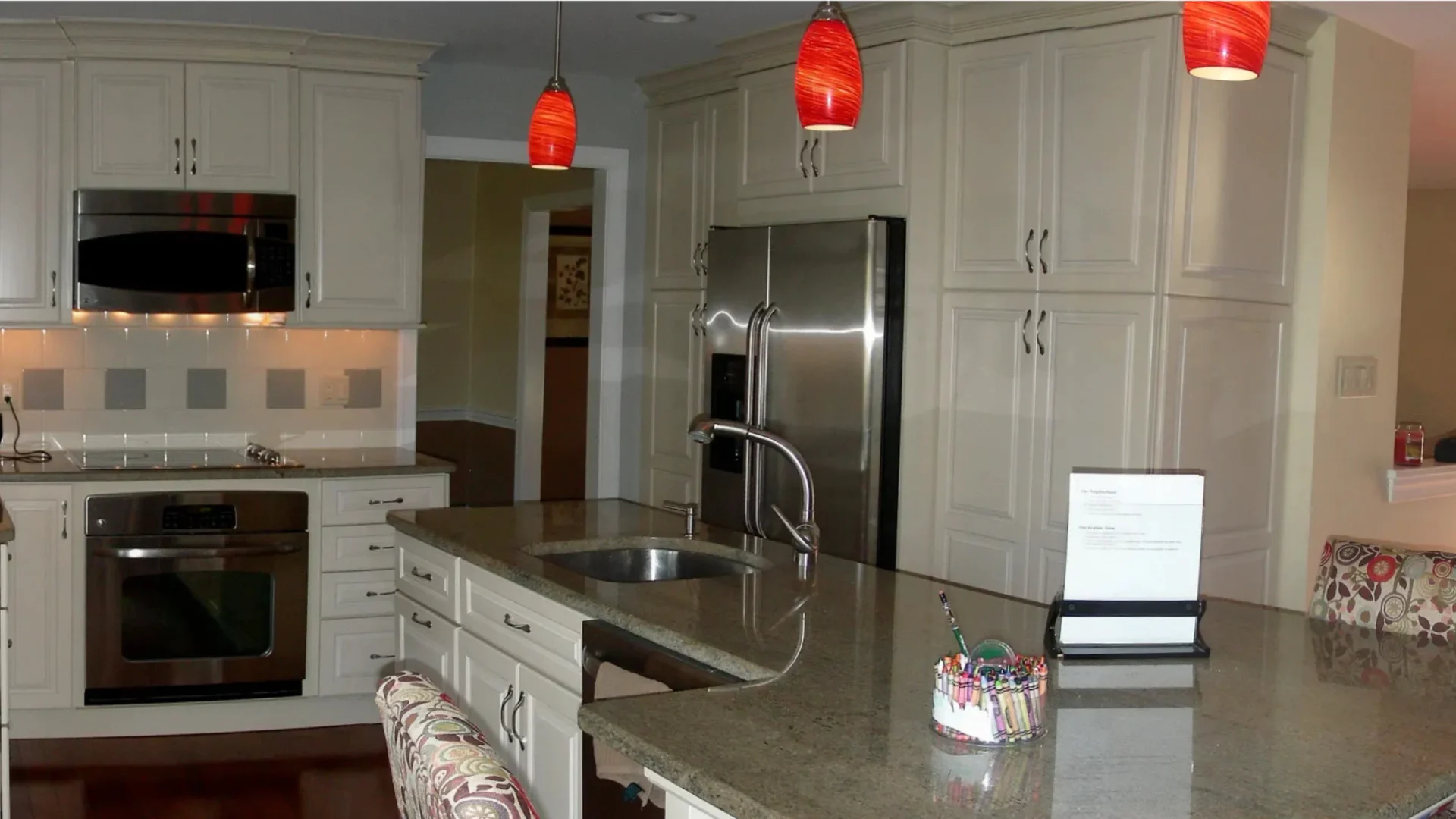 kitchen with island white cabinets and hanging red lights
